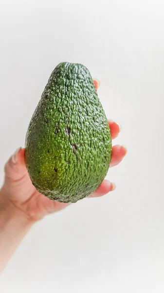 Reife Avocado Der Hand Weißer Bakkgrund Seitenansicht — Stockfoto