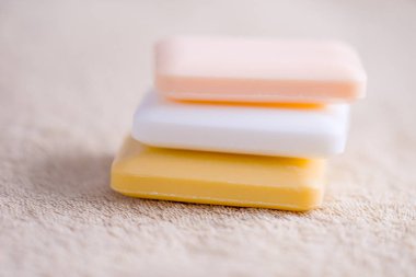 Üç kalıp sabun kahverengi bir havlu üzerinde. Yan görünüm