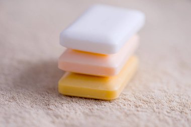 Üç kalıp sabun kahverengi bir havlu üzerinde. Yan görünüm