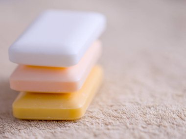 Üç kalıp sabun kahverengi bir havlu üzerinde. Yan görünüm