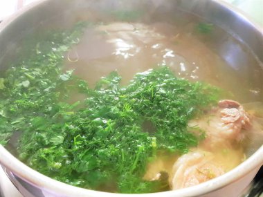 çorba yeşillik ve parça kuzu eti büyük bir tencerede pişirilir