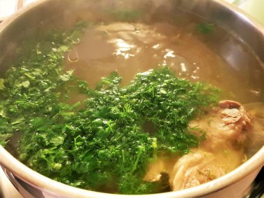 çorba yeşillik ve parça kuzu eti büyük bir tencerede pişirilir