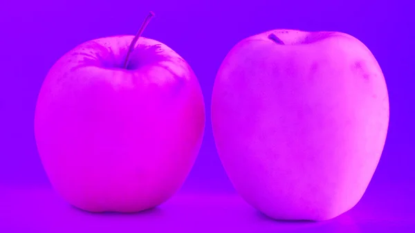 Два Розовых Яблока Столе Неоновом Фиолетовом Свете — стоковое фото