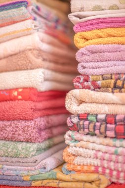düzgünce katlanmış rafta renkli pamuk havlular.