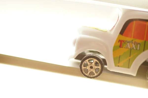 Witte auto speelgoed taxi in fel licht. — Stockfoto