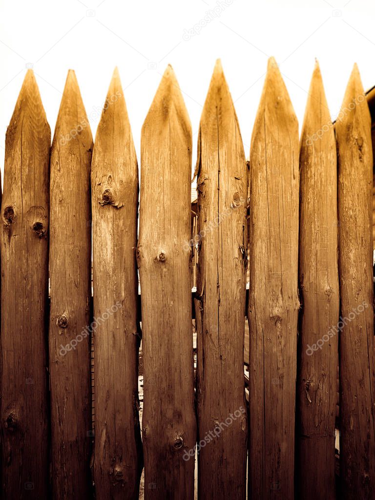 Sharp peaks on a wooden fence. Texture of wooden trunks.