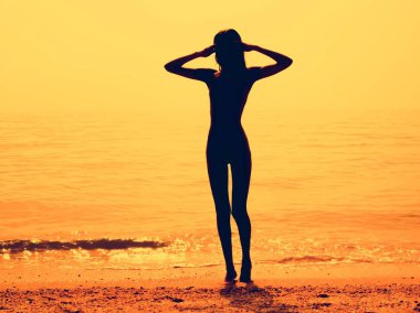 Sıska bir genç kız plaj boyunca silüeti