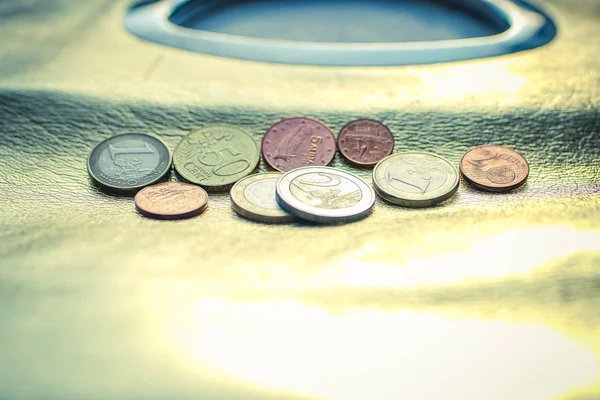 Monete in euro che giacciono su una borsa dorata lucida . — Foto Stock