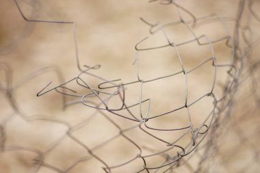 Dikenli Tel bükülmüş yırtılmış. Hasarlı çit. Makro fotoğraf. Seçici odak.