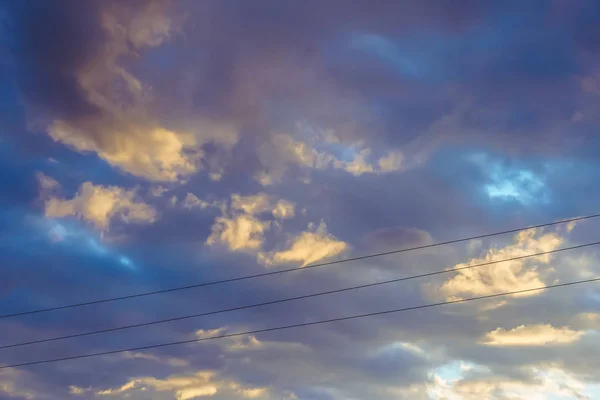 Imagen borrosa de un hermoso cielo azul con nubes y cables eléctricos al atardecer . —  Fotos de Stock