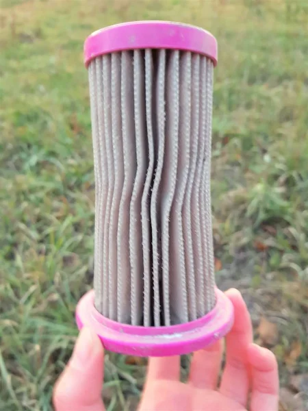 Mão segurando um filtro de aspirador de pó já limpo de poeira — Fotografia de Stock