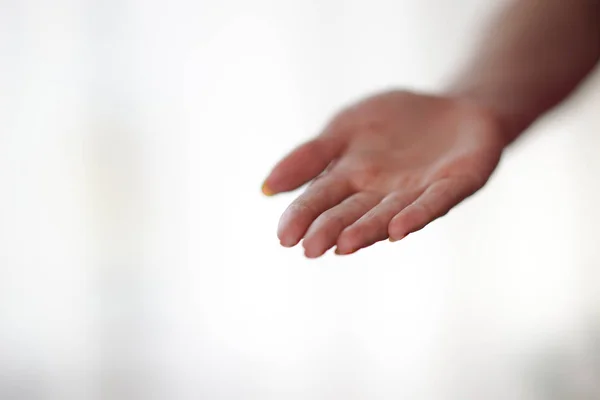 Kvinnlig hand med handflatan upp på en ljus bakgrund — Stockfoto