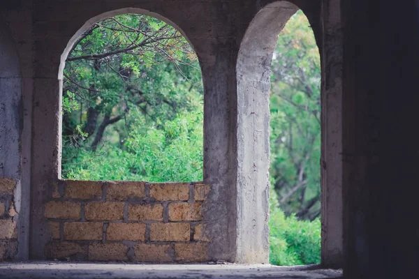 Arched big window and door in unfinished house of limestone