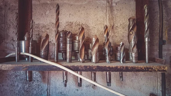 Een set van verschillende boren staan op een plank op een rij — Stockfoto