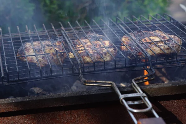 Gros morceaux de steaks de viande sur le gril — Photo
