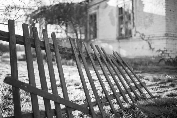 Starý rozbitý dřevěný plot a venkovský dům — Stock fotografie