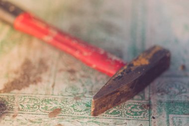 Eski kırmızı çekiç bir masa örtüsü ile masanın üzerinde yatıyor