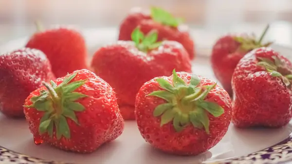 Große reife Erdbeeren in einem weißen Teller aus nächster Nähe. — Stockfoto