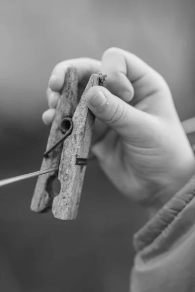 La mano de los niños toca la vieja pinza de madera que cuelga de la cuerda —  Fotos de Stock