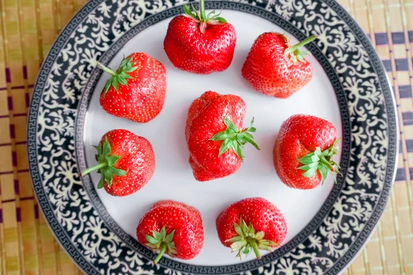 Grandes fraises dans une assiette avec une bordure bleue . — Photo