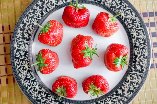 Fragole grandi in un piatto con un confine azzurro . — Foto Stock