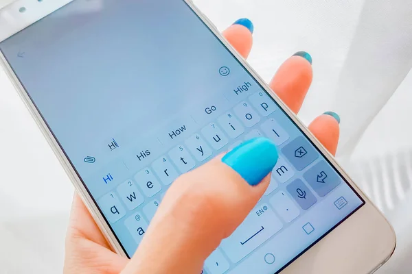 La mano femenina está escribiendo un mensaje en un teléfono inteligente — Foto de Stock