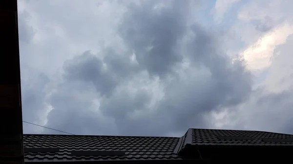 Escuro céu sombrio nas nuvens antes da chuva sobre os telhados das casas — Fotografia de Stock