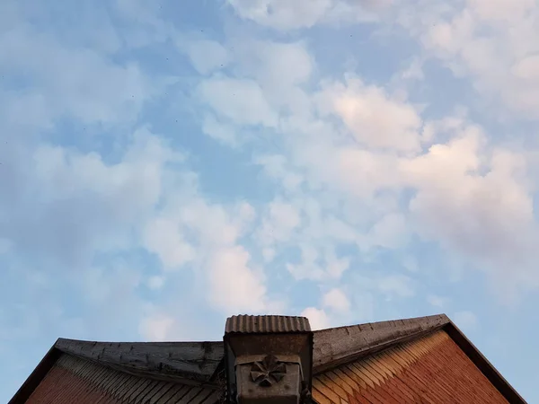 Kék ég fehér felhők, a tető a ház — Stock Fotó