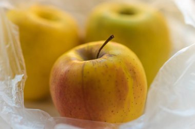 şeffaf bir pakette üç olgun elma