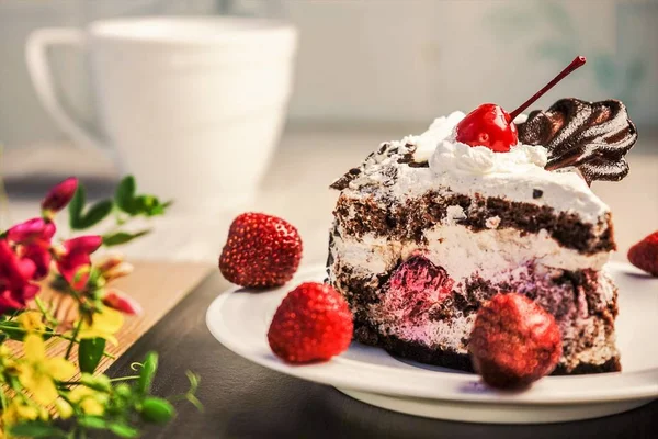 Pastel de galletas con crema y cerezas se encuentra en un platillo blanco, decorado con fresas . —  Fotos de Stock