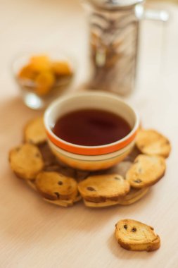 turuncu kase ve bir masada ekmek kırıntıları siyah çay