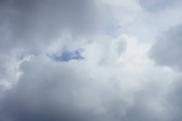 Μεγάλα γκρι σύννεφα του μεγάλου μεγέθους κάλυπταν σχεδόν ολόκληρο τον γαλάζιο ουρανό — Φωτογραφία Αρχείου