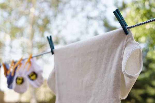La camiseta y los calcetines se secan en el tendedero en el jardín veraniego, lavando y cuidando la ropa . — Foto de Stock