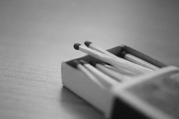 Caja de cartón abierta con cerillas en la mesa, foto en blanco y negro — Foto de Stock
