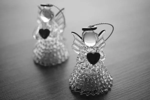 Two small statues of angels on the table, black and white photo. — Stock Photo, Image