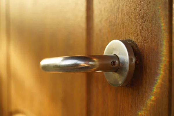 Bruine houten deur met chromen handvat en zonnige stralen — Stockfoto