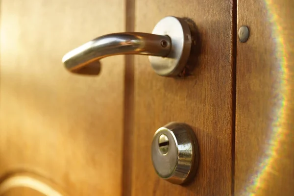 Bruine houten deur met chroom handvat en sleutelgat, mooie zonnestralen — Stockfoto