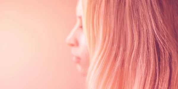 Female pink hair on a pastel background, side view portrait with blurred face. — Stock Photo, Image