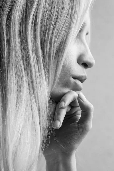 Portrait doux d'une jeune fille avec la main sous le menton, vue de profil, photo en noir et blanc — Photo