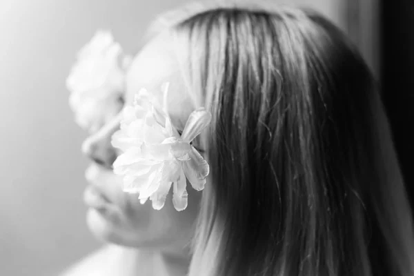 Retrato borrado de uma jovem com flores no cabelo, sonhos femininos e prazer. Foco suave seletivo. Preto e branco . — Fotografia de Stock