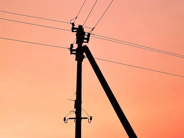 Silhueta preta de um pólo elétrico com céu crepúsculo rosa . — Fotografia de Stock