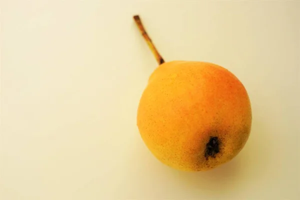 Fruta de pera madura naranja amarilla en backgorund ligero — Foto de Stock