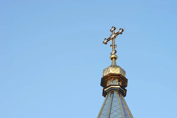 Der obere Teil des Daches der orthodoxen Kirche mit einem Kreuz vor blauem wolkenlosen Himmel. — Stockfoto