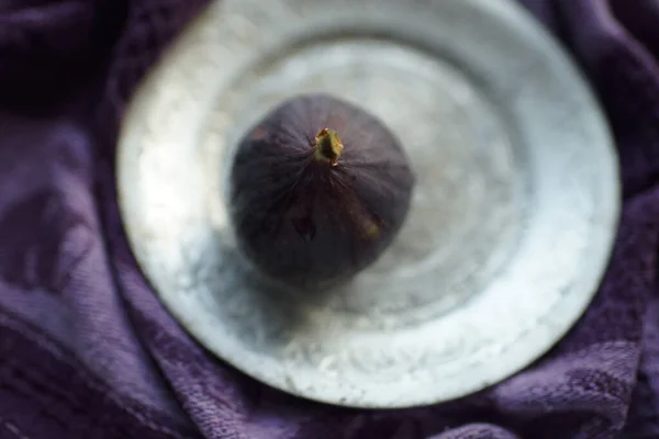 Zralý fík na stříbrném talíři a fialový ubrus. Selektivní soustředění. Rozmazané. — Stock fotografie