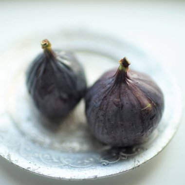 Gümüş bir tabakta iki taze incir yakın plan.