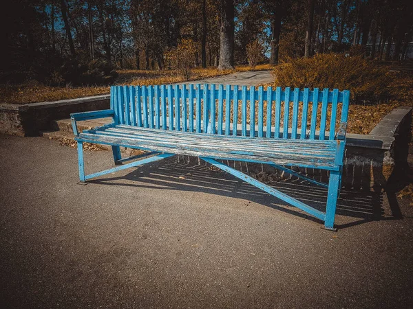 Güneşli sonbahar parkında eski mavi ahşap bank — Stok fotoğraf