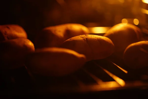 Pommes de terre entières dans la peau cuite au four noir. Aliments sains — Photo