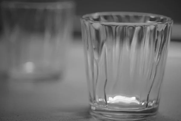 Tomt glas på bordet, svart och vitt foto — Stockfoto
