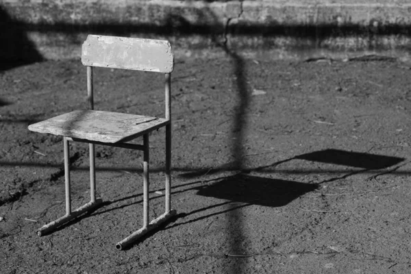 Régi szék a vidéki udvaron. Aszfaltkő padló. Kemény fény és árnyék. Testvér. — Stock Fotó