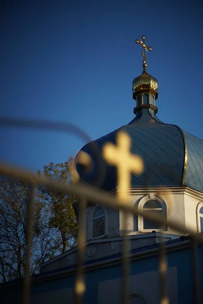 Visão da Igreja Ortodoxa através de uma cerca com uma cruz em borrão . — Fotografia de Stock